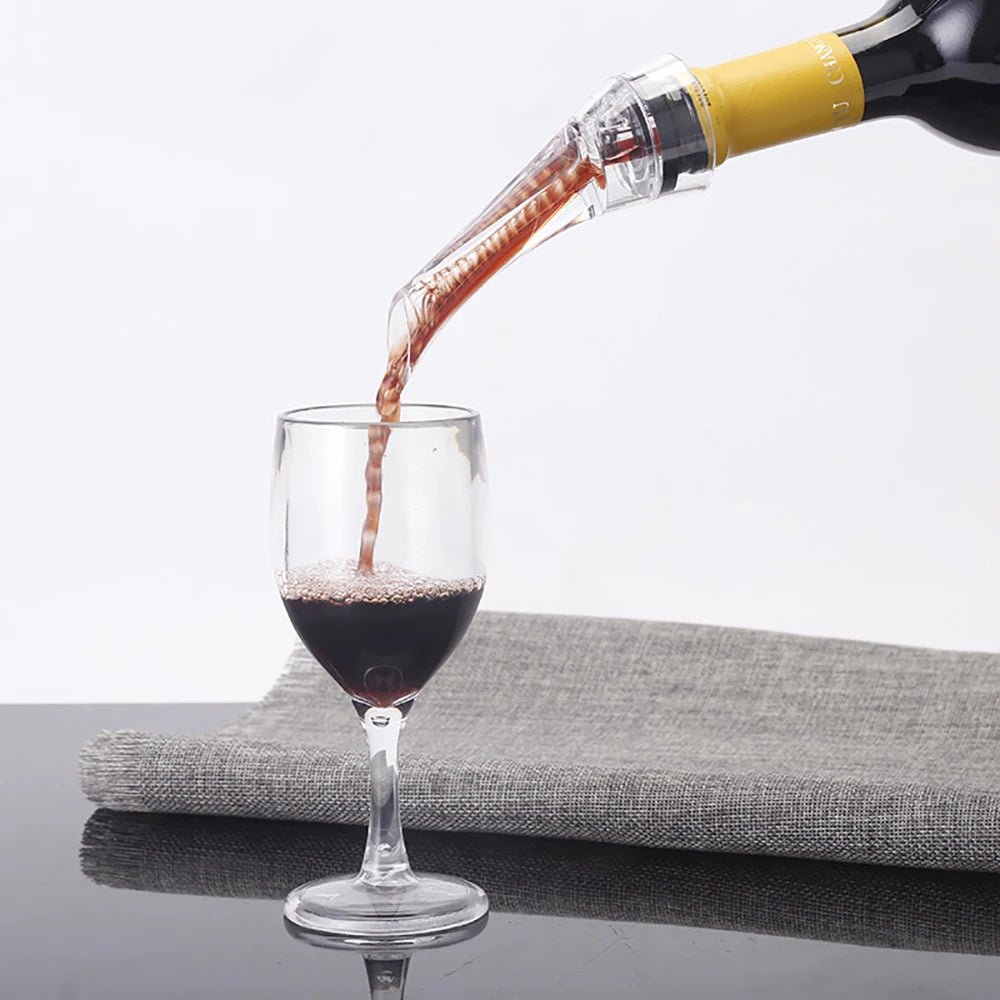 Wine aerator pourer spout pouring red wine into a glass from a clear outlet