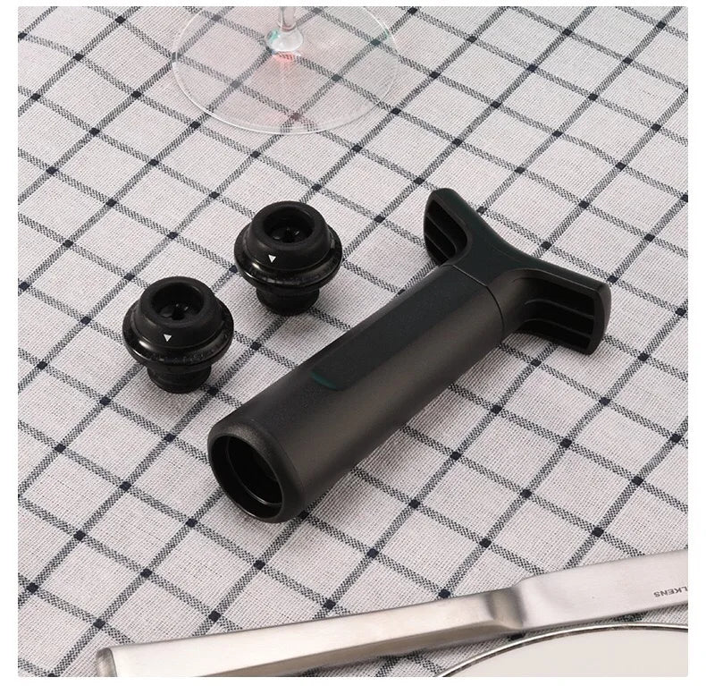 Black manual wine vacuum pump with four reusable silicone stoppers on checkered cloth