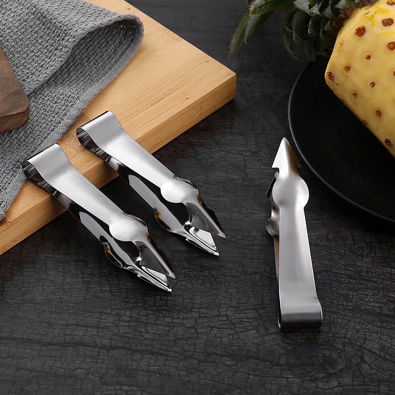 Stainless steel V-shaped fruit huller tweezers set beside spare blade and handle
