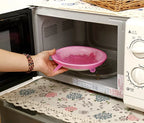 Pink silicone stretch lid placed in microwave over a container