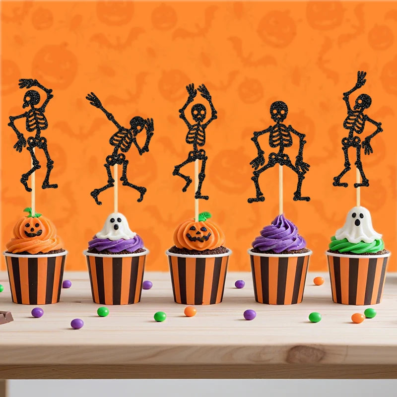Black skeleton cupcake toppers on cupcakes with white, purple, and orange frosting