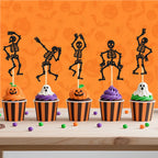 Black skeleton cupcake toppers on picks on frosted Halloween cupcakes