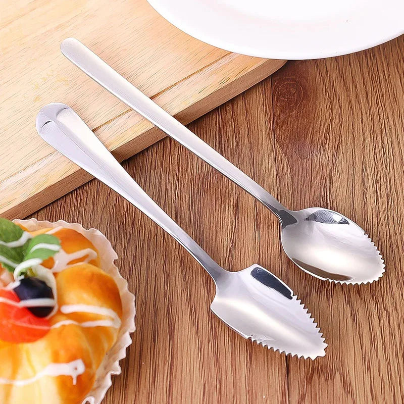 Two stainless steel spoons with micro-serrated tips for citrus carving on wood