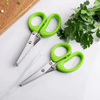 Green-handled herb shears with stainless multi blades on a board with fresh herbs