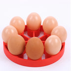Red silicone egg steamer rack holding nine eggs in individual wells