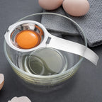 Stainless steel egg yolk and white separator with yolk cup resting on bowl rim