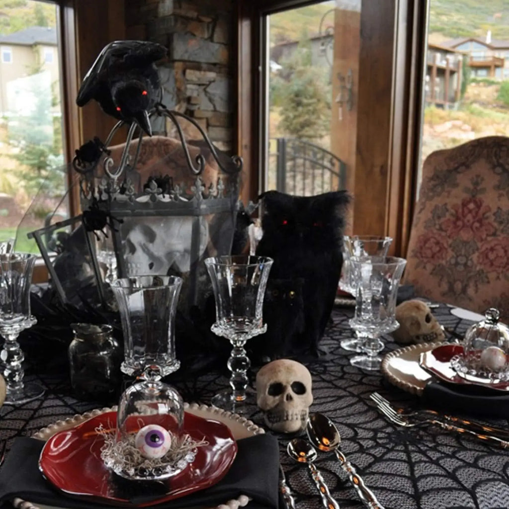 Black spider web lace table runner covering tabletop with scalloped edge