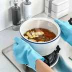 Blue silicone dishwashing scrubber glove scrubbing a pot filled with soup