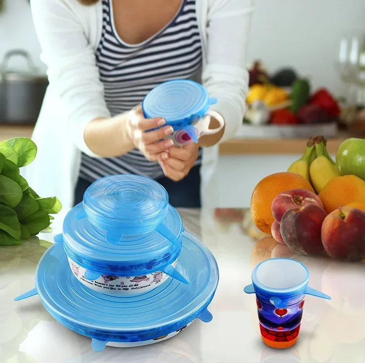 Blue silicone stretch lids being held over cups and bowls for airtight storage