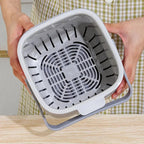 Close-up of open gray countertop compost bin with vented inner drain tray