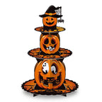 Three-tier Halloween jack-o-lantern pumpkin cupcake stand with ghost decorations and witch hat topper on white background.