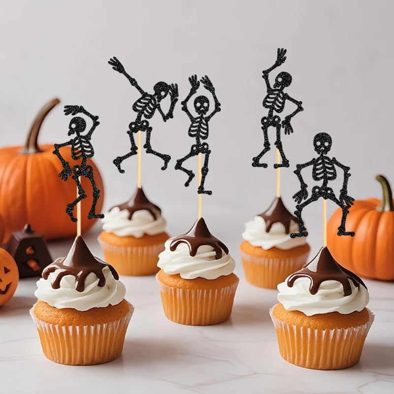Black skeleton cupcake toppers on picks standing in cupcakes