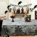 Black lace table runner with spider web and bat motifs, scalloped edges