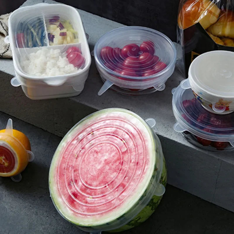 Silicone stretch lids with pink and blue tones covering food containers on a table