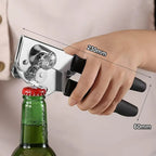 Hand holding manual can opener on green bottle; chrome head and black handle