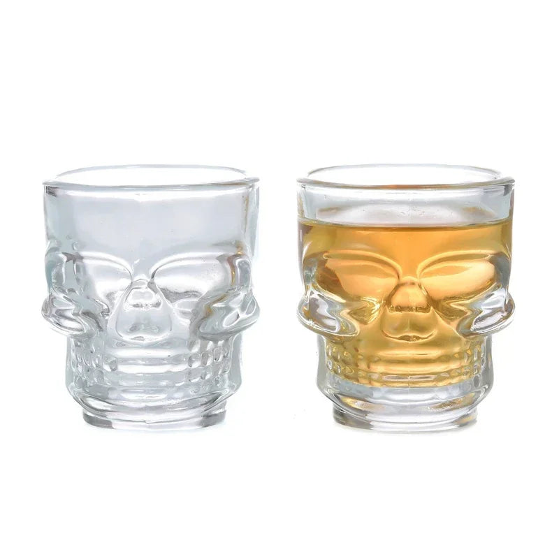Pair of skull shot glasses: clear and gold-tinted with mirrored face design