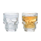 Pair of skull shot glasses: clear and gold-tinted with mirrored face design