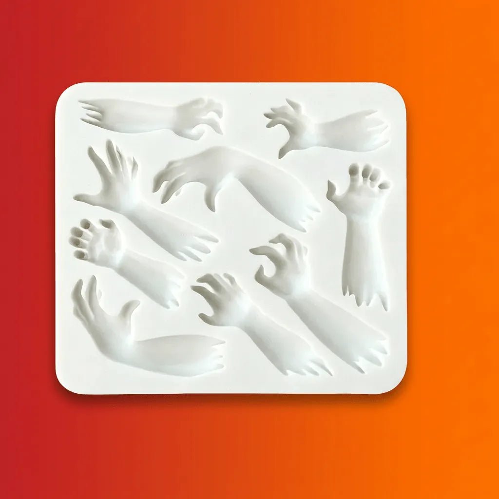 White silicone Halloween mold with multiple zombie hand and arm shapes on orange-red gradient background.