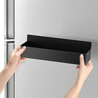 Black magnetic refrigerator storage basket with open top, held by two hands