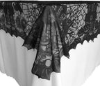Black lace table runner with spider-web pattern and scalloped hem