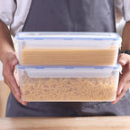 Clear airtight bread storage box with blue lid and seal, carried in both hands