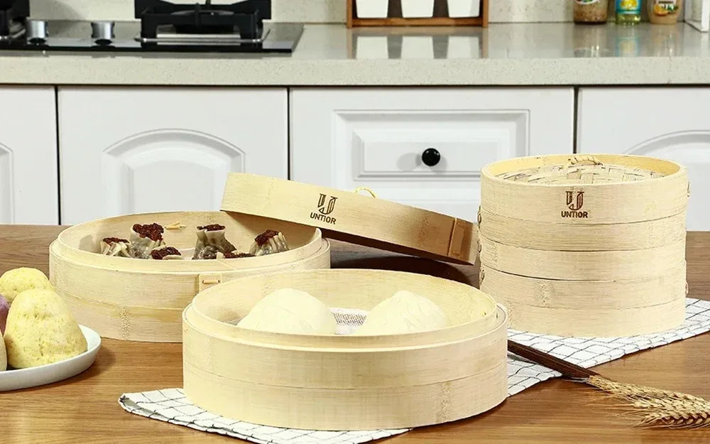 3-tier natural bamboo steamer basket set with lids, stacked on countertop