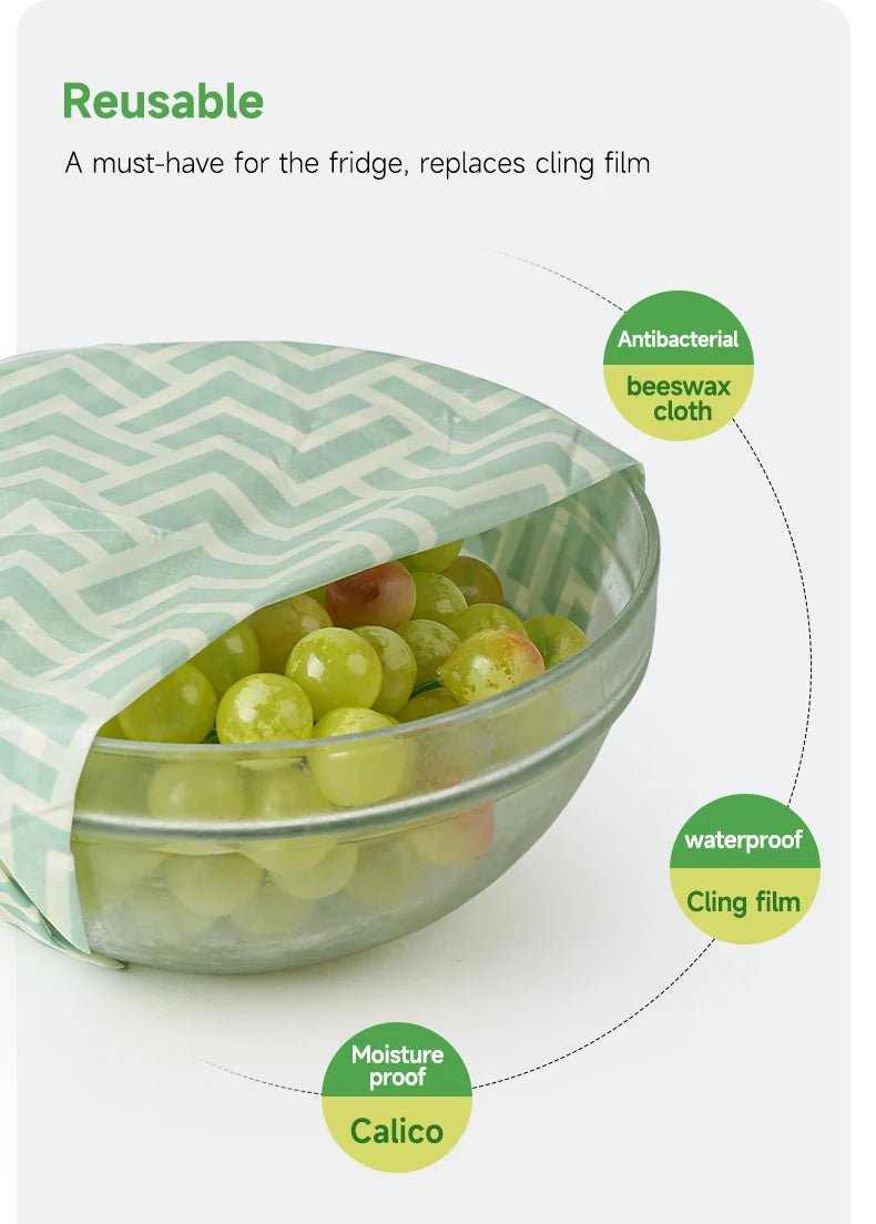 Reusable beeswax food wrap over a bowl of green grapes, teal zigzag fabric layer