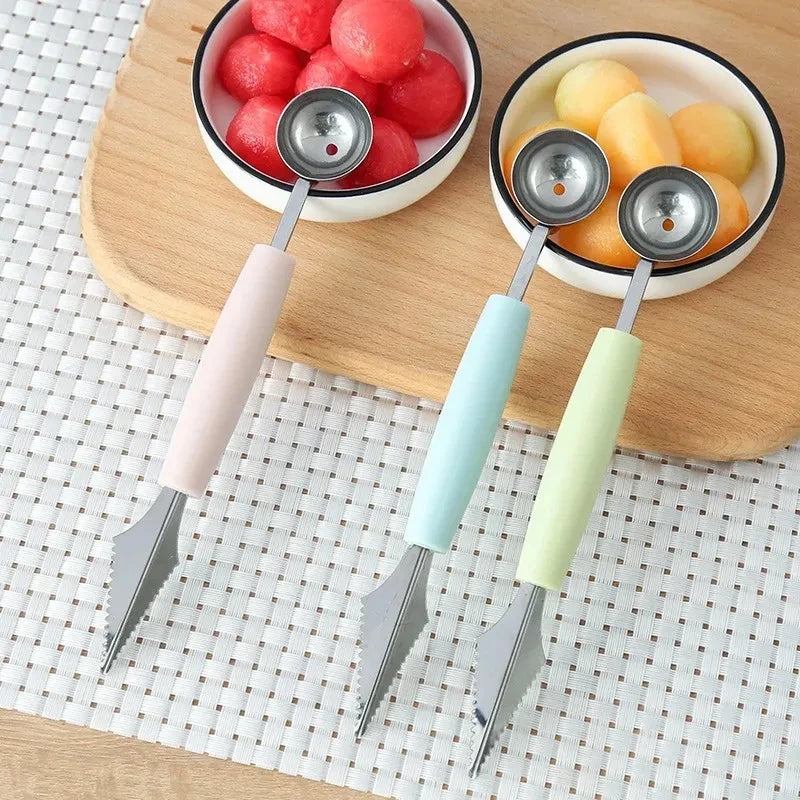 Stainless steel dual scoop fruit baller tool set with pastel handles on placemat