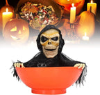 Orange glowing skull bowl haunted prop with hooded skeleton face and black webbed cloth