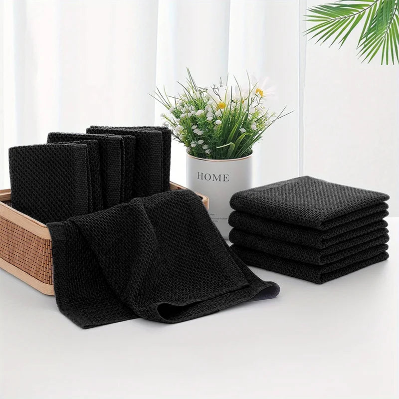 Black waffle weave kitchen towels and dishcloths folded on countertop