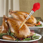 Red meat injector resting in roasted turkey with a visible stainless needle