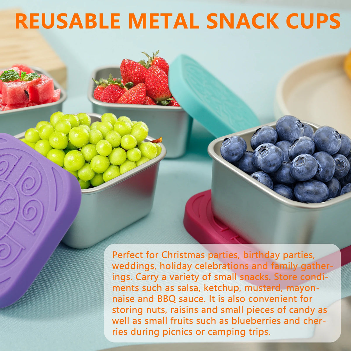 Four small stainless snack cups with colorful silicone lids, filled with fruit