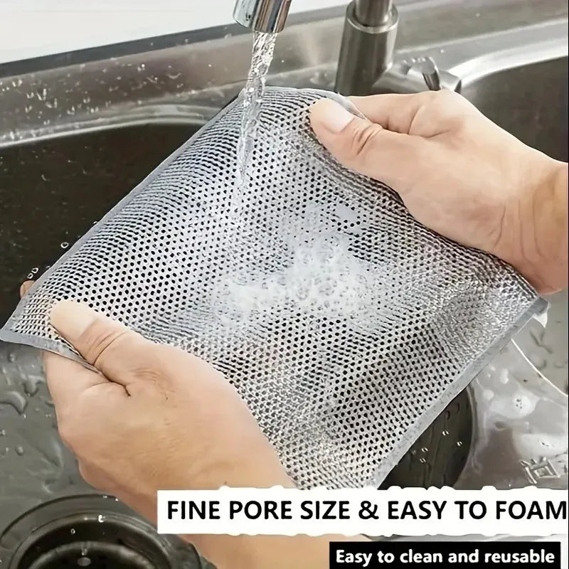 Grey wire mesh scrubbing cloth held over running water in a kitchen sink