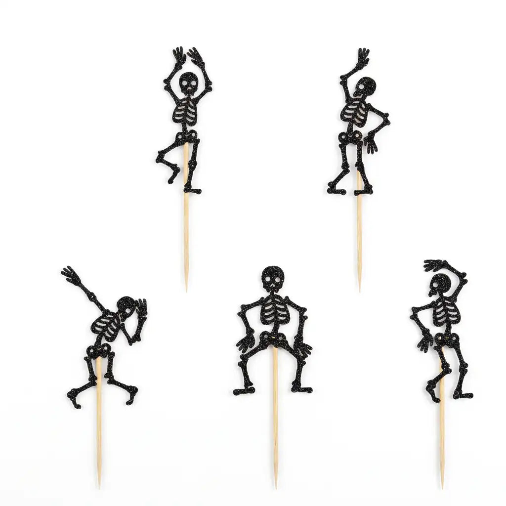 Five black glitter skeleton Halloween food picks on sticks on white background.