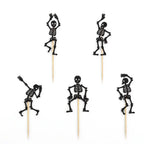 Five black glitter skeleton Halloween food picks on sticks on white background.