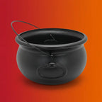 Black plastic Halloween cauldron with lid and wire handle on orange-red gradient background.