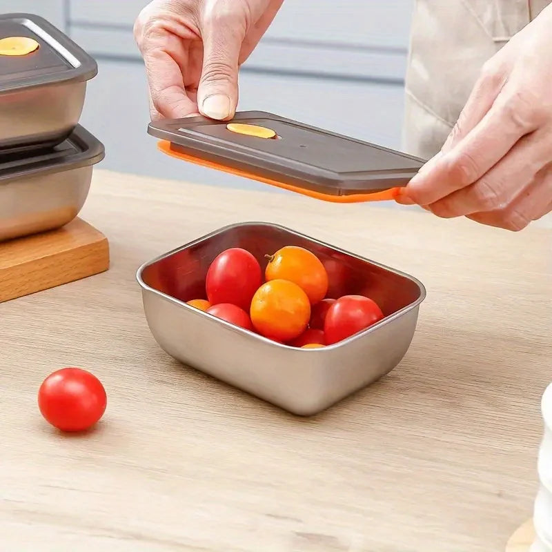 Stainless steel food storage container with vented lid, shown with ripe tomatoes inside