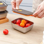 Stainless steel food storage container with vented lid, shown with ripe tomatoes inside