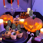 Halloween cupcakes topped with black tombstone toppers and shovel picks