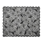 Black lace Halloween tablecloth with spider web pattern, bats, and spiders on white background.