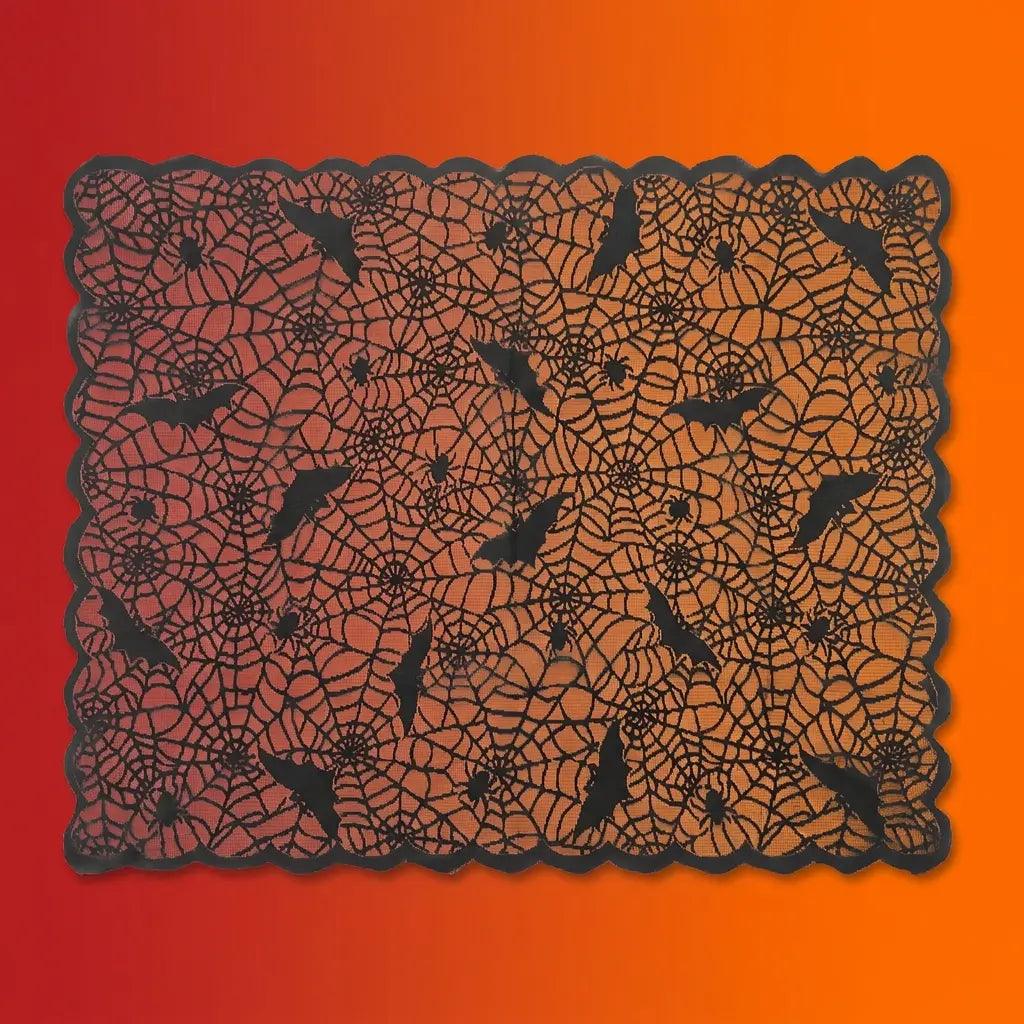 Black lace Halloween tablecloth with spider web pattern, bats, and spiders on orange-red gradient background.