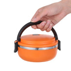 Orange stainless steel bento lunch box with black carry handle and side latch tabs