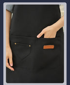 Matte black waterproof canvas chef apron with adjustable neck and large front pockets