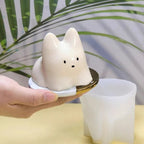 White cat pudding silicone mold with hand-held cat insert over basin