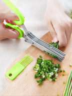 Multi-blade herb shears with green handles and stainless blades, mincing herbs on a cutting board