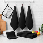 Black waffle weave kitchen towels hanging with folded dishcloth stack