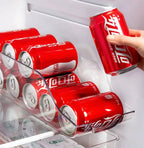 Clear can holder bin with built-in handles storing stacked soda cans in the fridge