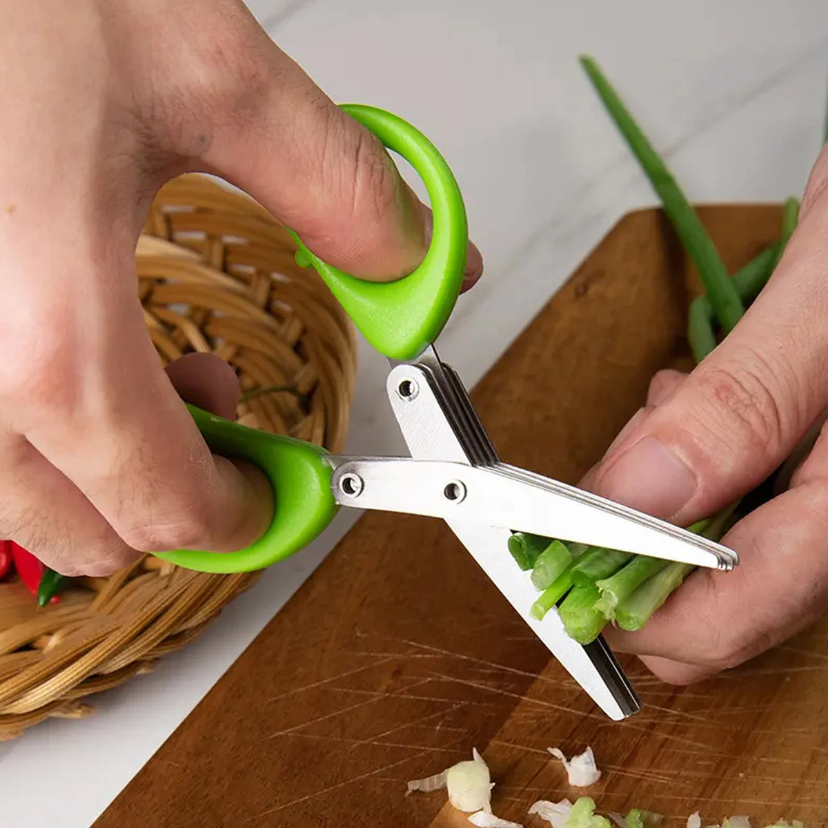 Green-handled herb shears with stainless multi blades, slicing scallions over a cutting board