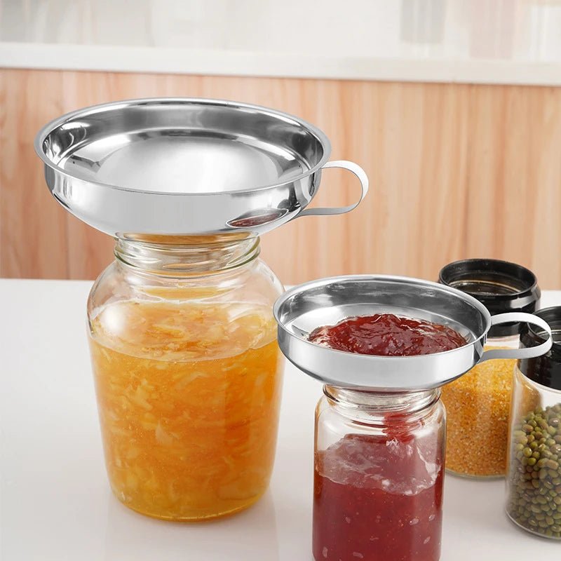 Stainless steel canning funnels with wide openings and side handles on glass jars