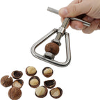 Hands using stainless steel manual nutcracker and sheller on a nut